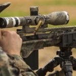 Man scoping on sniper rifle