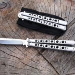 butterfly knives on a wood surface open and closed