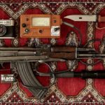 black and brown ak-47 near black and gray camera and tactical knife place on red and gray area rug