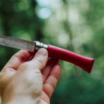 hand holding a short knife with bokeh background