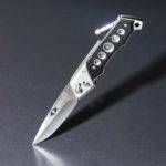 gray and black folding knife on gray surface