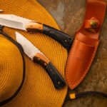 two edc fixed blades on top of a hat